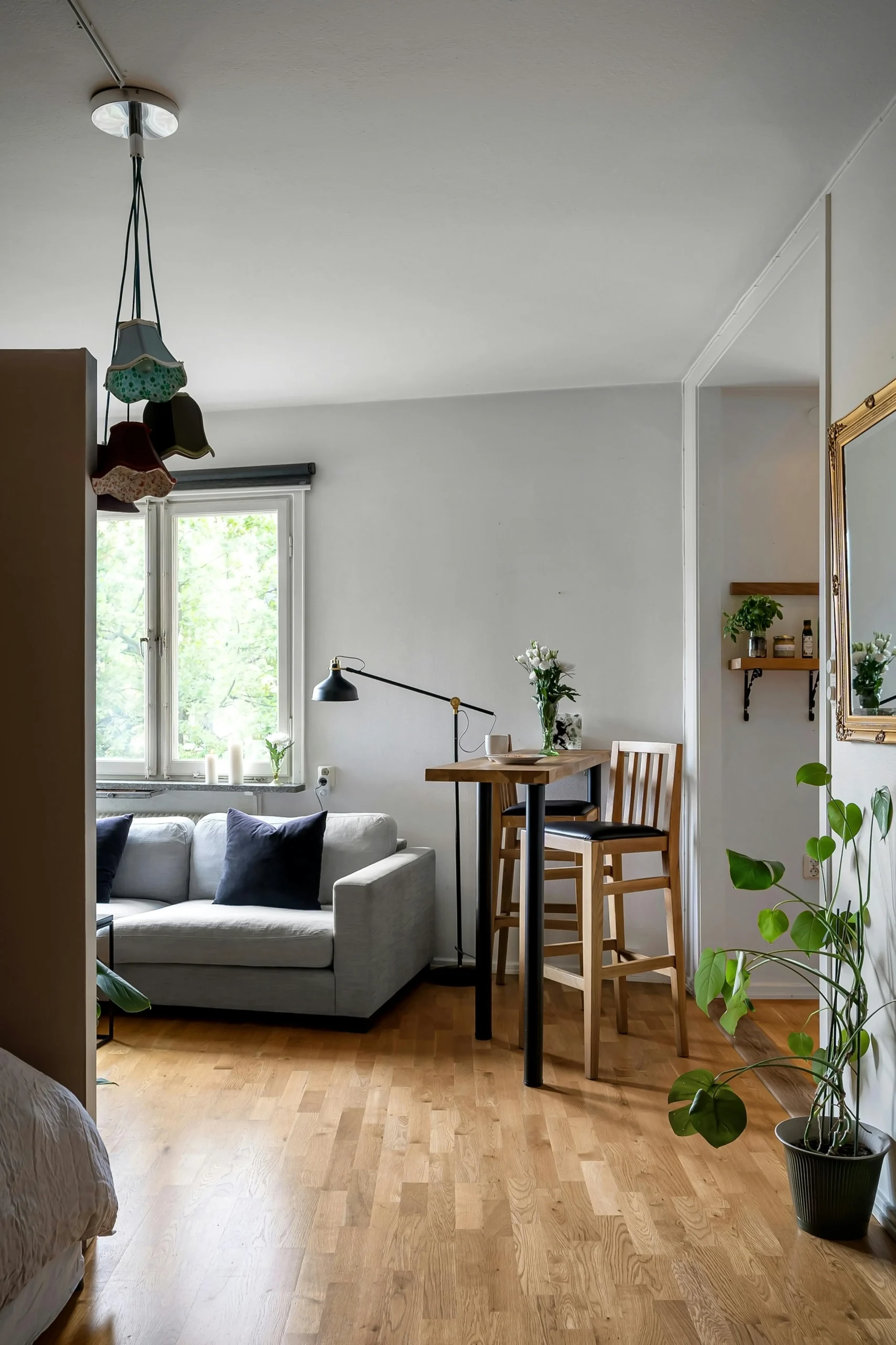 A framed artwork placed in relationship to furniture and surrounding objects.