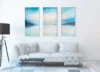 Ethereal Horizon Symphony triptych anchoring a refined white living room, large scale art for living rooms that ask for presence.