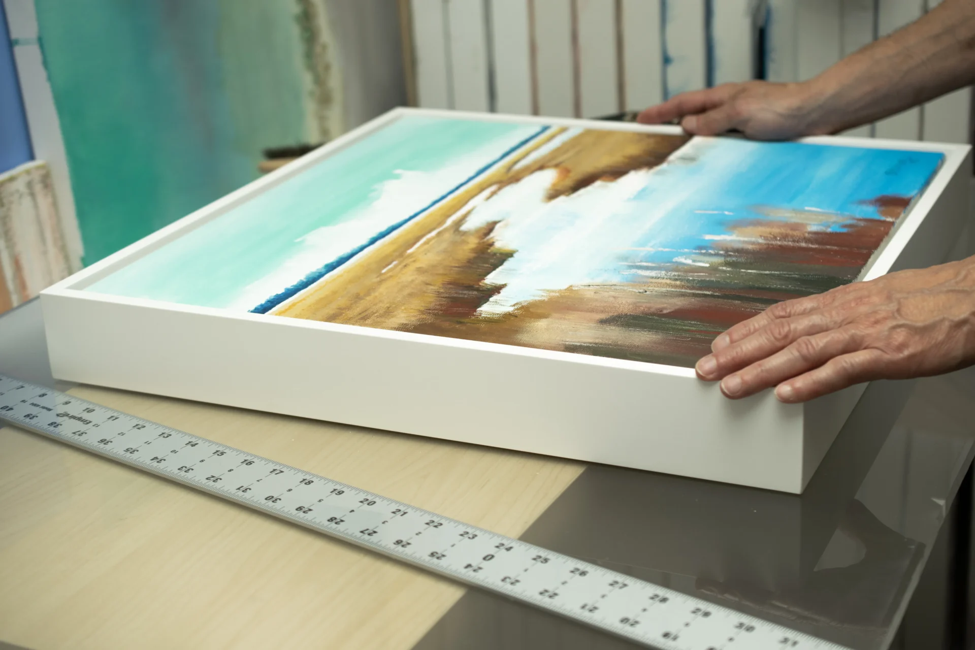 A studio workshop scene showing a limited edition print being hand-finished with texture and color accents.