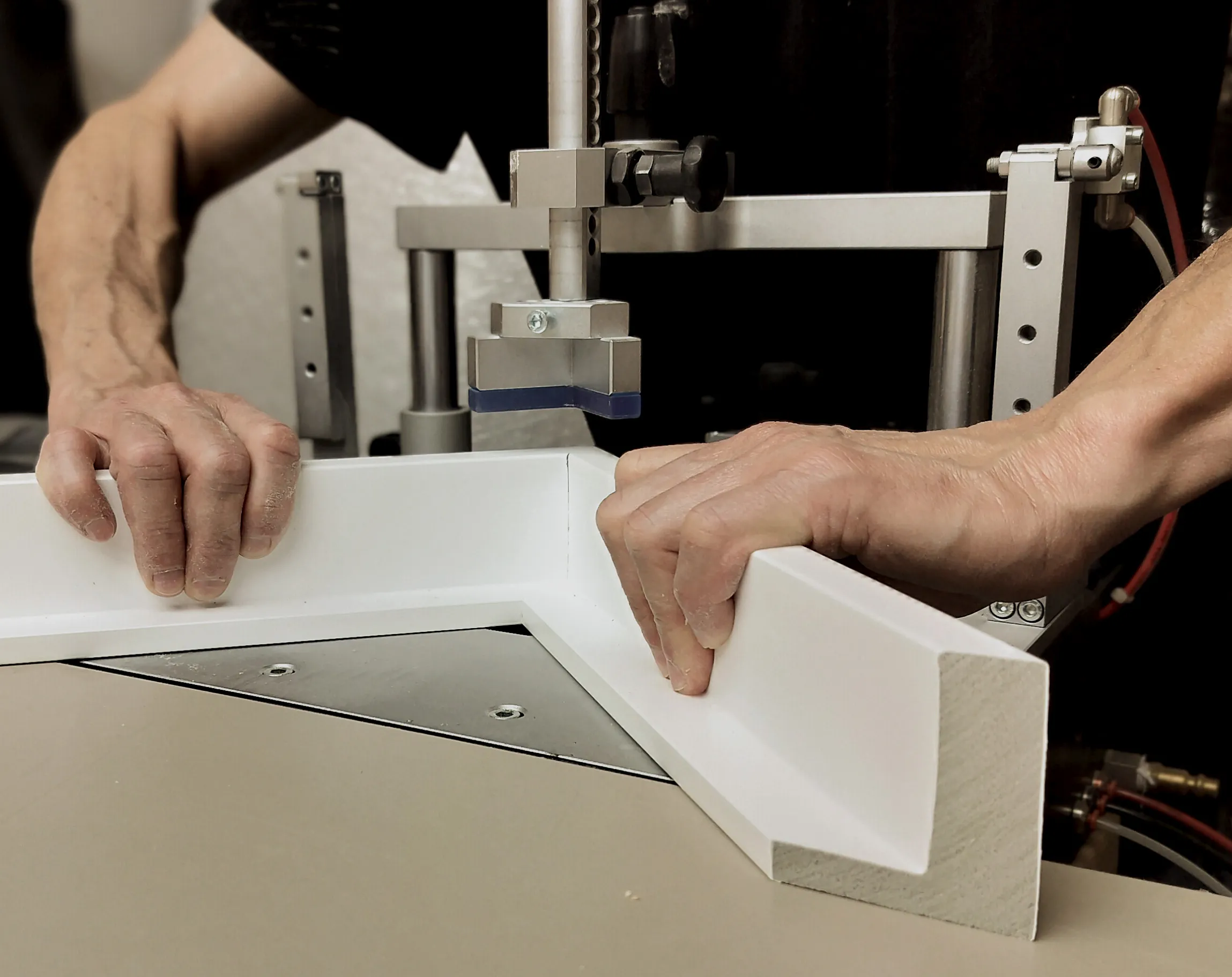 A framing workshop with moulding, tools, and a frame being assembled by hand.