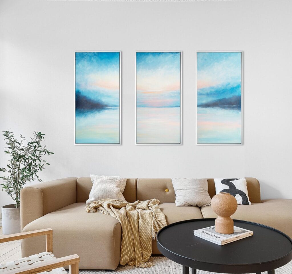 Ethereal Horizon Symphony original acrylic triptych displayed above a beige sofa in a warm neutral living room.